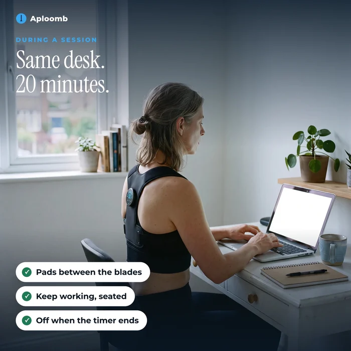 A woman working at a laptop during a 20-minute PostureFit session